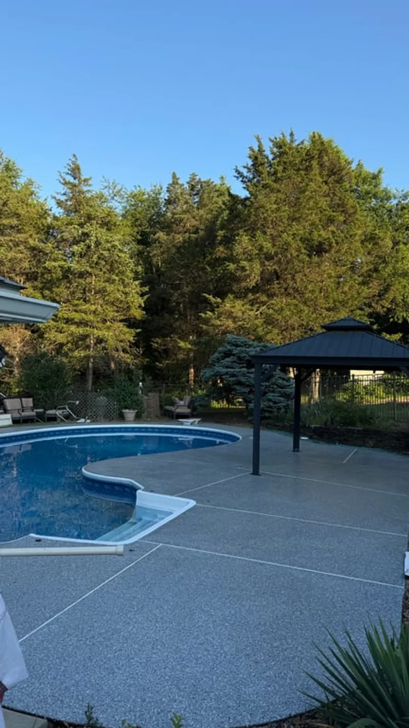 Finished pool deck with Simiron Tidal Wave Stonewash flake coating surrounding inground pool and gazebo in Hillsborough Township, NJ