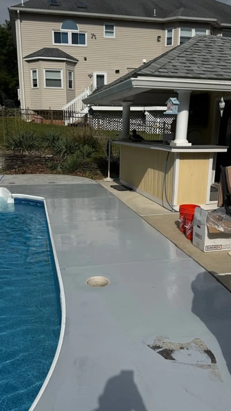 Simiron moisture vapor barrier base coat applied to pool deck concrete in Hillsborough Township, NJ during flake system installation process